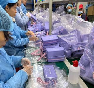 Factory worker inspecting and kitting silicone personal care items for export
